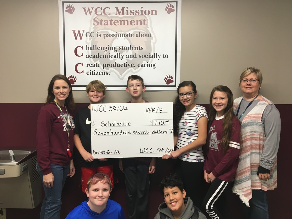 Students and teachers holding check
