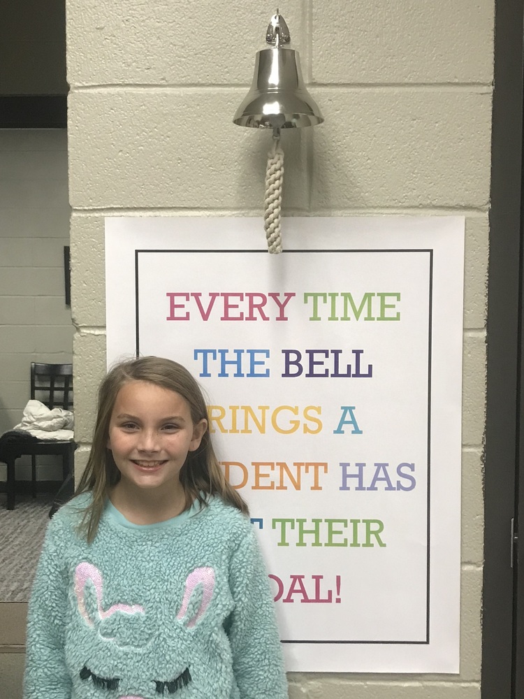 Ava Lowe standing by bell