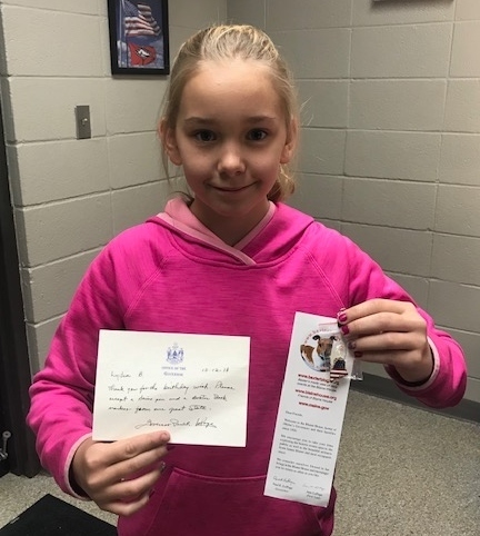 Student holding letter and bookmark
